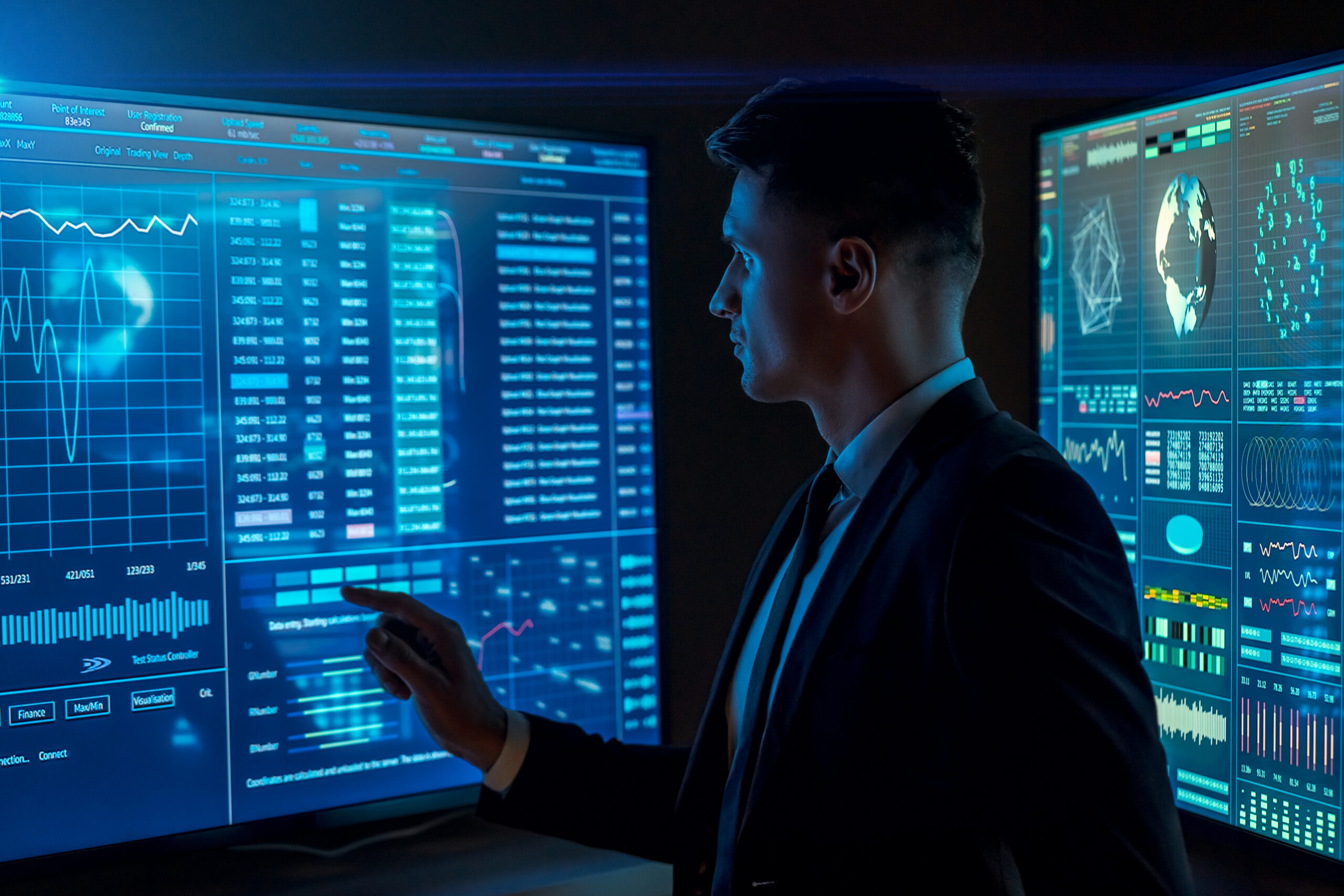 The man working on a sensor blue display in the dark space